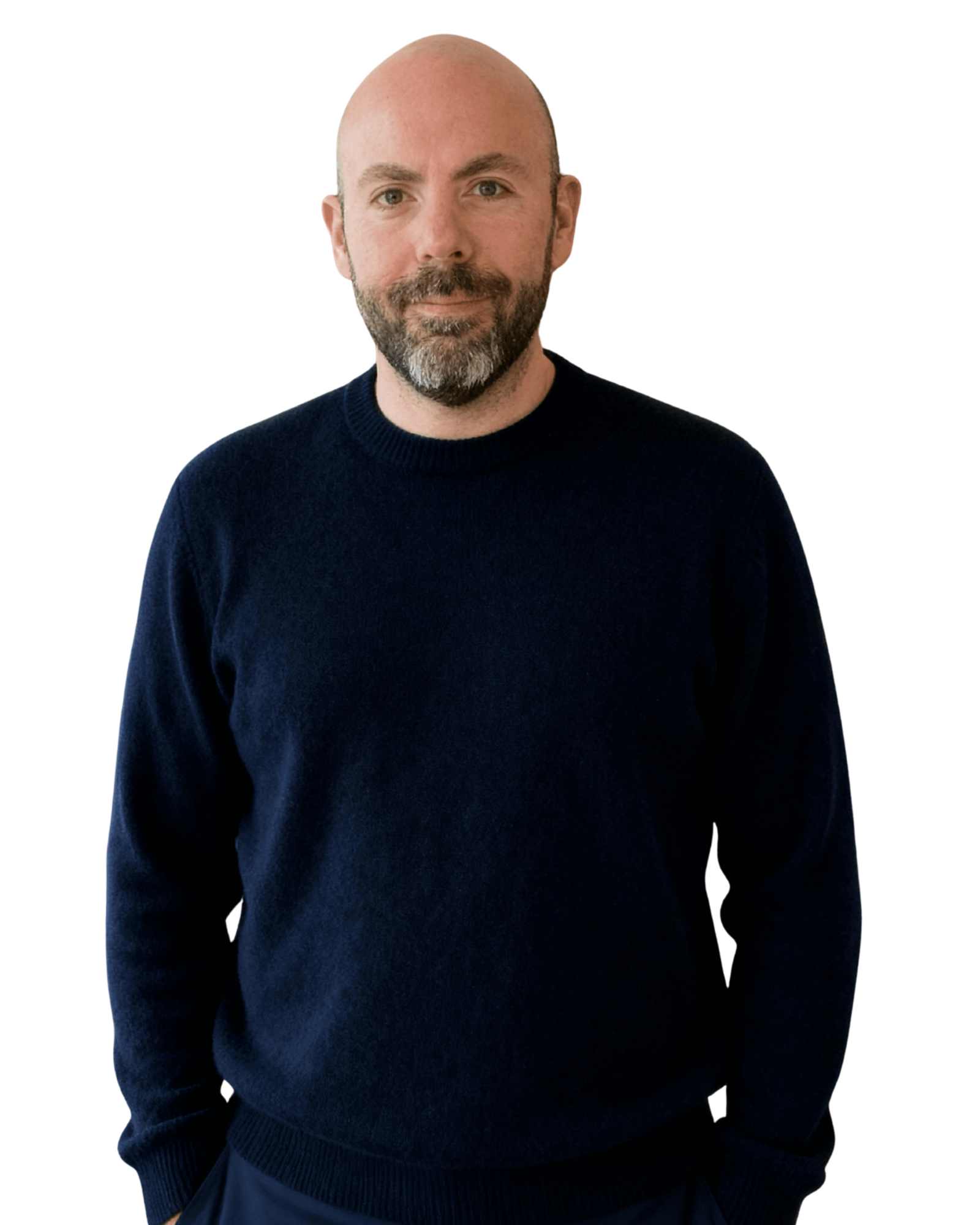 Bald man with beard wearing navy sweater standing and looking at camera