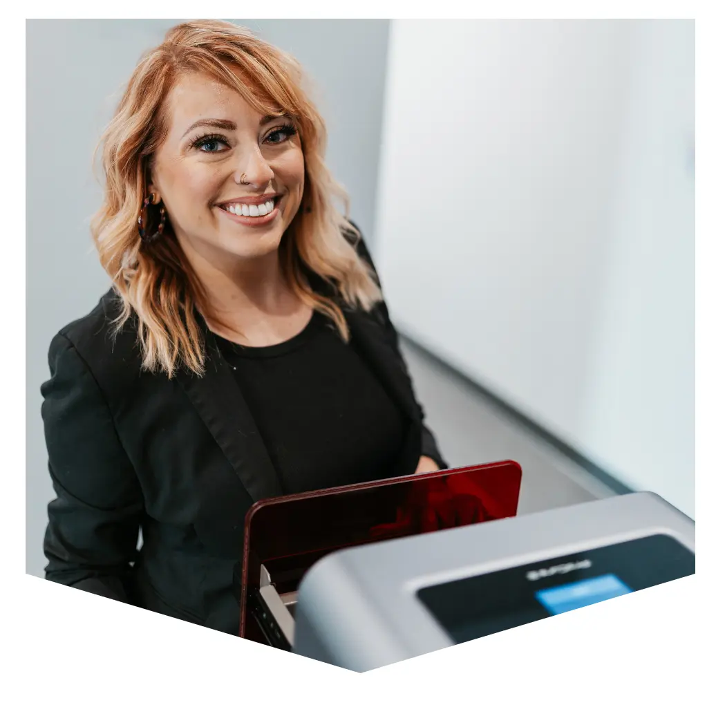 Smiling woman using dental scanner and laptop in modern clinic